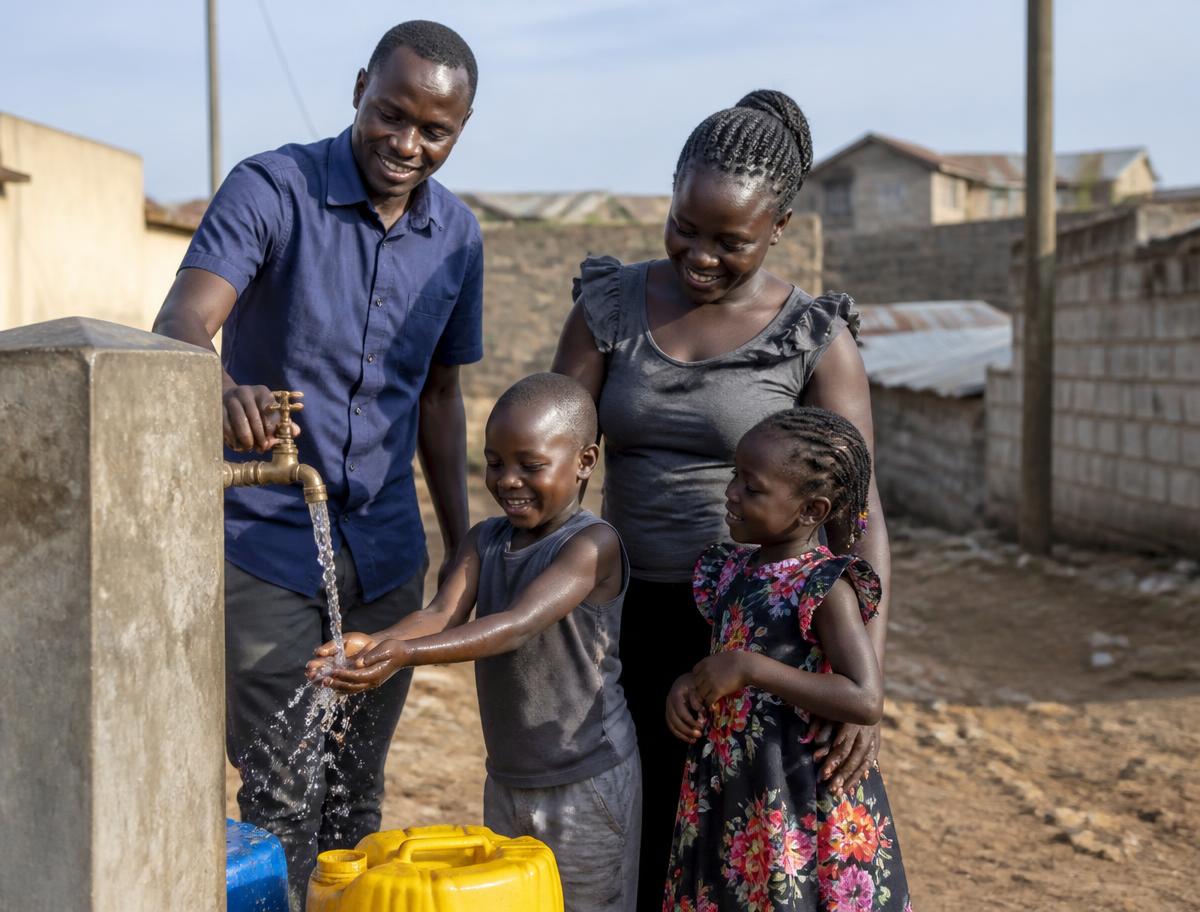 A family collecting clean water from a household tap in a Kajiado neighbourhood